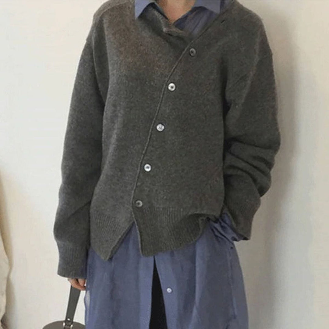 Nora asymmetric button cardigan in gray, front view styled with a blue shirt and handbag