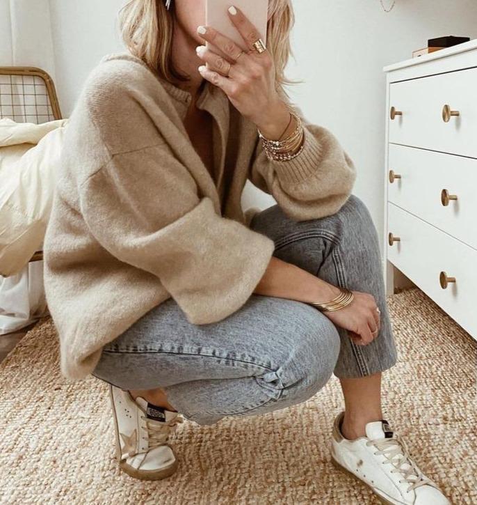 Woman crouching wearing Sienna cardigan with jeans and sneakers